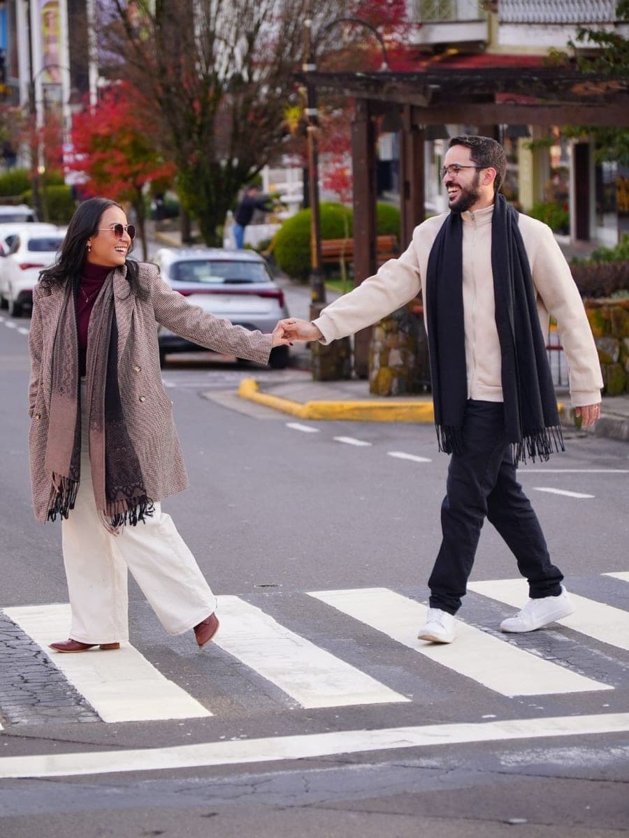 Casal atravessando a faixa de pedestres de mãos dadas em Gramado