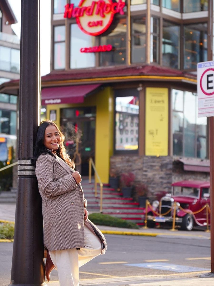 Mulher sorrindo em frente ao Hard Rock Cafe de Gramado
